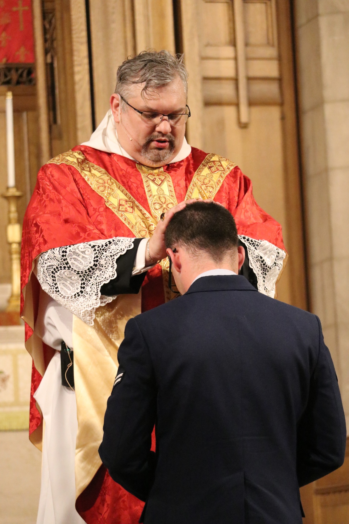 The newly ordained gives a blessing to his husband.