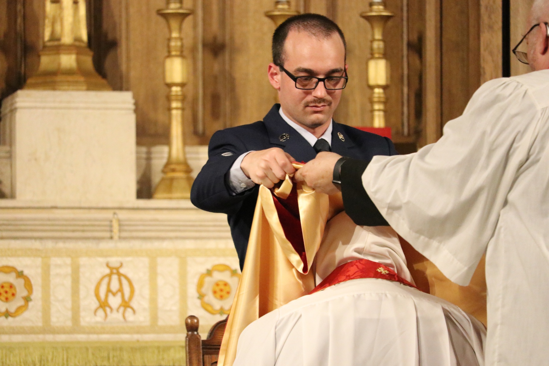 The vesting of the newly ordained priest in stole and chasuble.